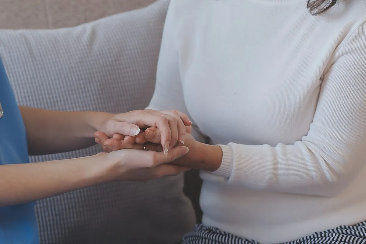 A carer holding a client's hands